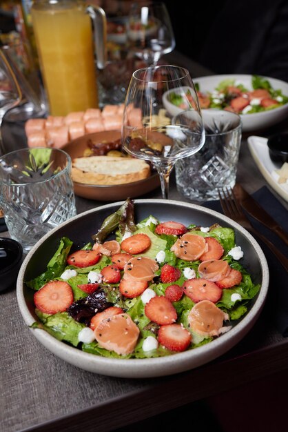 Lachssalat mit Spinat Kirschtomaten Feldsalat Babyspinat frische Minze und Basilikum Hausgemachtes Essen Konzept für eine leckere und gesunde Mahlzeit Dunkler Steinhintergrund Draufsicht Nahaufnahme