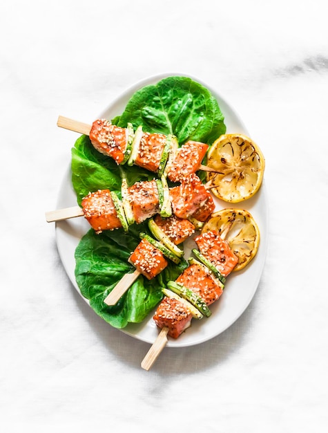 Lachsspieße mit Zucchini und Sesam auf hellem Hintergrund Draufsicht Köstliche Vorspeisen-Tapas-Mittagessen