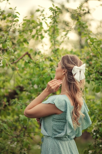 Laço de grampo branco na vista traseira do cabelo feminino no jardim florescente