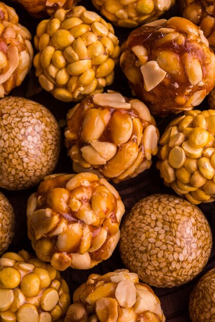 Laddoo saludable con maní tostado, sésamo y Daliya dividido con jaggery, servido en una placa de madera, enfoque selectivo