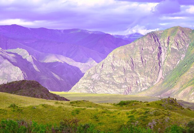 Laderas rocosas cubiertas de hierba bajo un cielo nublado azul Siberia Rusia