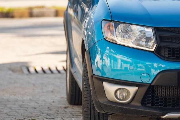 Lado do carro azul com farol claro, pára-choques, porta, faróis de neblina