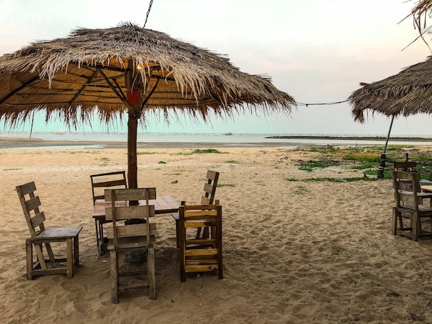 Lado de sillas con paraguas en el fondo de la playa