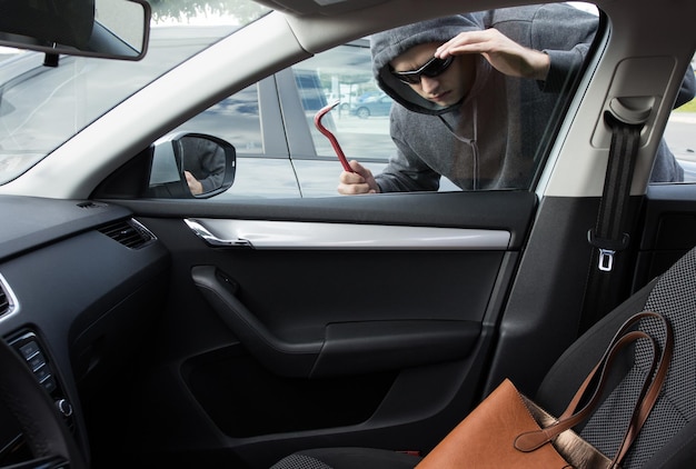 Ladrão quebrando em um carro