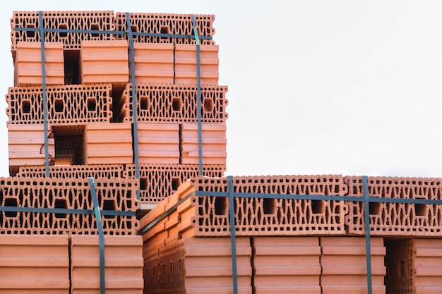 Foto ladrillos cerámicos en el mercado de la construcción en la calle contra el cielo