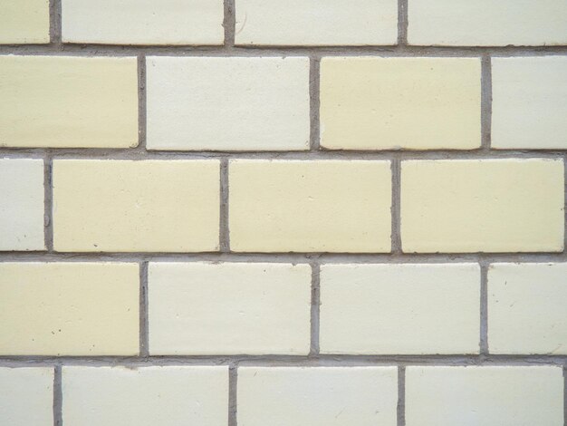 Ladrillos de diferentes colores se colocan uniformemente Muro de piedra amarilla y blanca