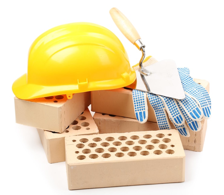 Foto ladrillos nuevos y herramientas de construcción aisladas en blanco