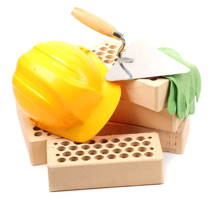 Foto ladrillos nuevos y herramientas de construcción aisladas en blanco