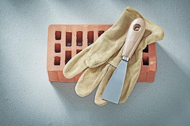 Ladrillos rojos guantes de seguridad paleta de yeso sobre fondo de hormigón concepto de albañilería.