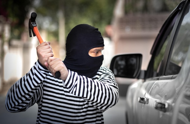 Ladrón de autos secuestra y roba o roba dinero en autos y autos rompiendo la ventana de la puerta sin alarma de auto ilegal y trabajo criminal violento