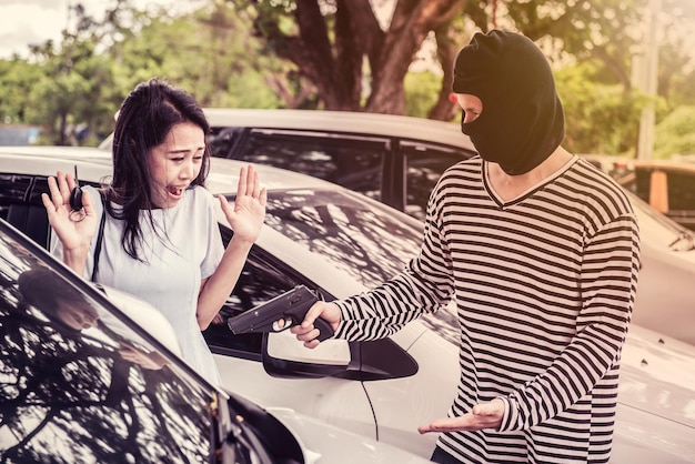 Ladrón está tratando de robar el auto en el estacionamiento público.