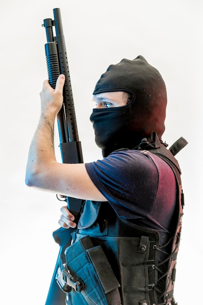 Foto ladrón, hombre armado con escopeta y chaleco antibalas