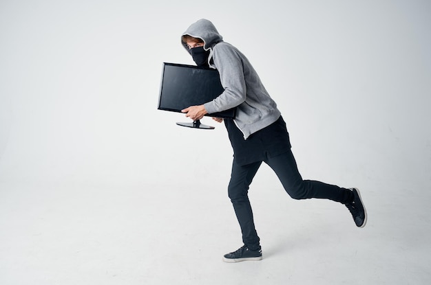 ladrón masculino con cabeza encapuchada tecnología de piratería de seguridad fondo de luz foto de alta calidad