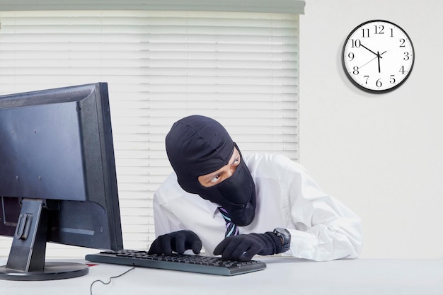 Ladrón rompiendo computadora en la oficina