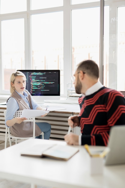 Lady coder dando información sobre la aplicación a un colega