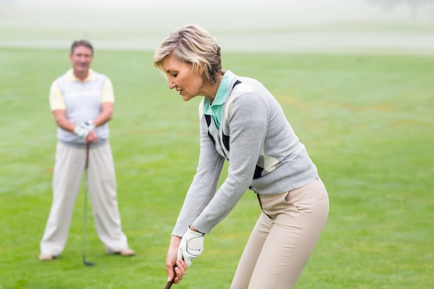 Lady golfista vai sair para o dia visto pelo parceiro