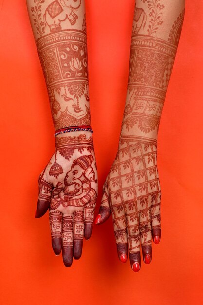 Foto lady hand füße mit indischer heena in indischer hochzeit mit orangefarbenem hintergrund