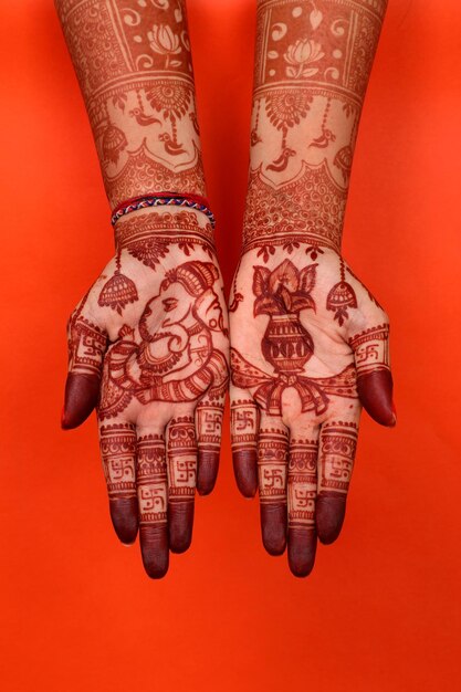 Foto lady hand füße mit indischer heena in indischer hochzeit mit orangefarbenem hintergrund