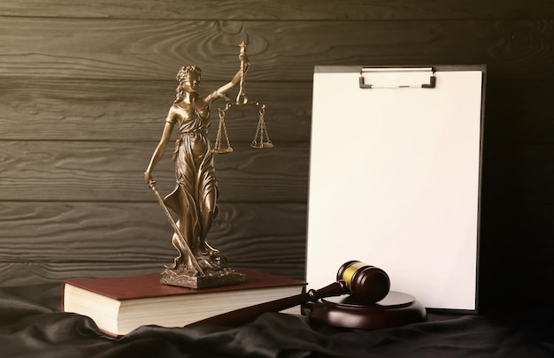 Lady Justice oder Justitia die römische Göttin der Gerechtigkeit Statue auf braunem Buch mit Richter Hammer auf