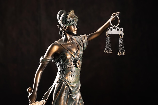 Lady Justice oder Themis oder Justilia (Göttin der Gerechtigkeit) auf schwarzem Hintergrund