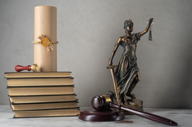 Lady Justice, Richterhammer, Bücher, Pergamentrolle mit Siegel und Stempel auf einem alten Holztisch