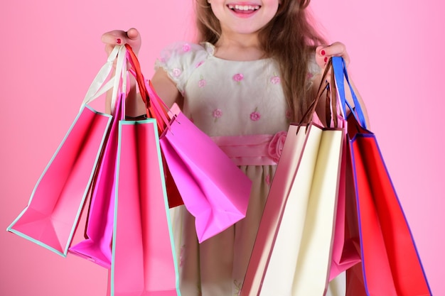 Lady Shopper in Kleid gewelltes Haar Mädchen hält Einkaufstüten