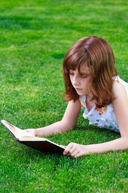 Lady.Young hermosa chica leyendo un libro al aire libre