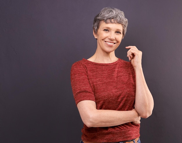 Lächeln lohnt sich Studioporträt einer selbstbewussten älteren Frau vor grauem Hintergrund