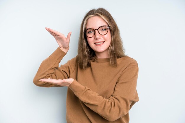 Lächeln, sich glücklich, positiv und zufrieden fühlend, Objekt oder Konzept auf Kopienraum haltend oder zeigend