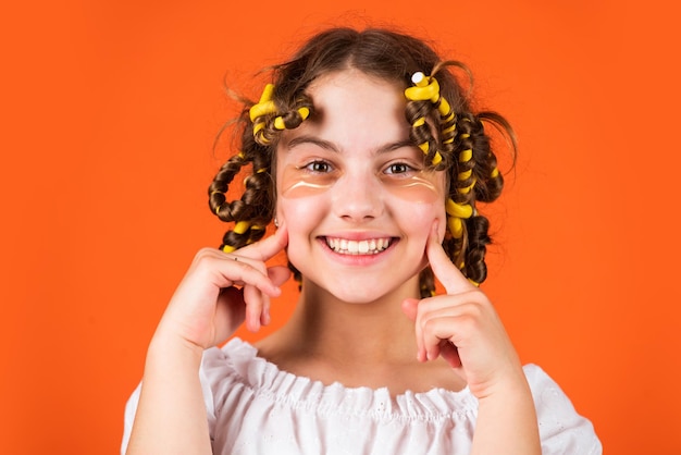 Lächeln Sie einfach Stoffmaske unter den Augen für die Schönheit niedliches Kind, das mit Flecken unter den Augen steht Kindermode-Modell-Konzept Kind, das Frisur macht kleines glückliches Mädchen mit Lockenwicklern im Haar