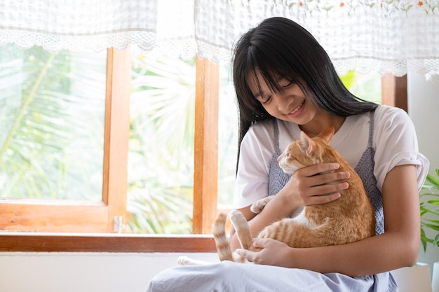 Lächeln Sie junges Mädchen mit einer Katze zu Hause