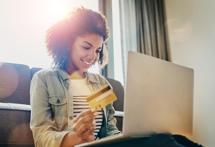 Foto lächeln sie kreditkarte und frau mit laptop auf dem sofa für investitionstransaktionen und zahlungsinformationen zuhause und entspannen sie sich mit fintech im wohnzimmer für online-glücksspiel digital banking und einzahlung