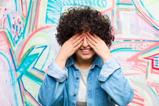 lächeln und sich glücklich fühlen, die Augen mit beiden Händen bedecken und auf eine unglaubliche Überraschung warten