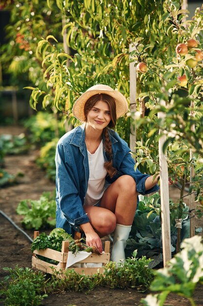 Foto lächelnd sitzt eine schöne junge frau im garten