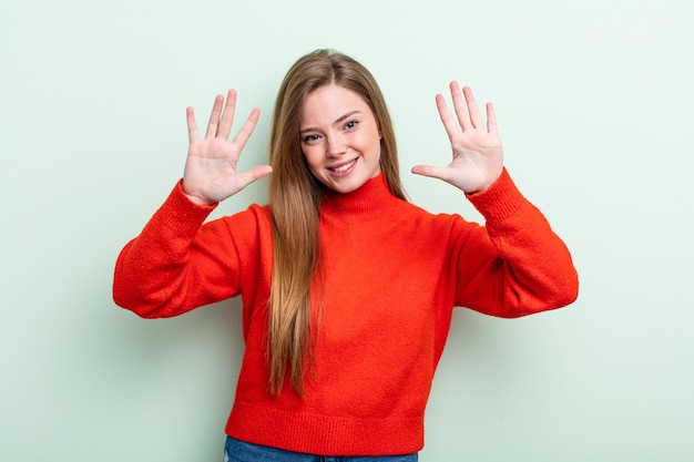 lächelnd und freundlich aussehend mit der Nummer zehn oder zehn, wobei die Hand nach vorne zählt