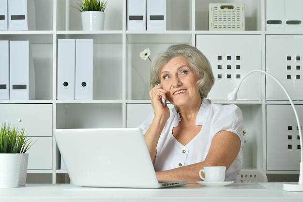 Lächelnde ältere Frau, die am Telefon spricht