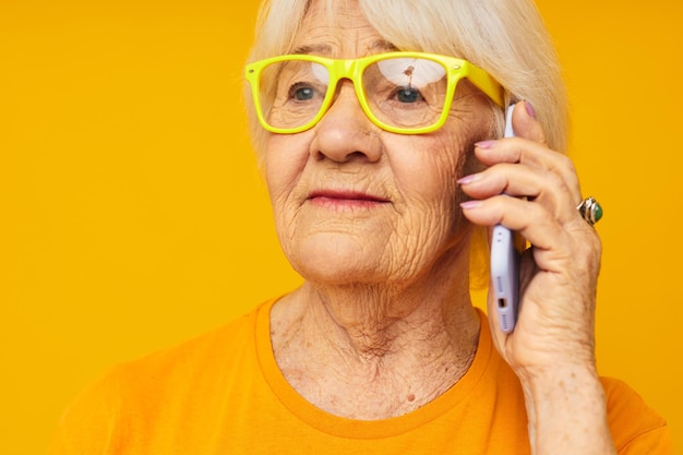 Lächelnde ältere Frau in lässiger T-Shirt-Kommunikation per Telefon, Nahaufnahme von Emotionen