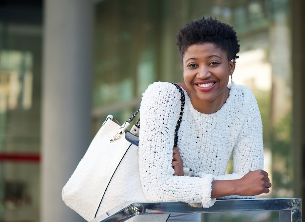 Lächelnde Afroamerikanerfrau mit Tasche