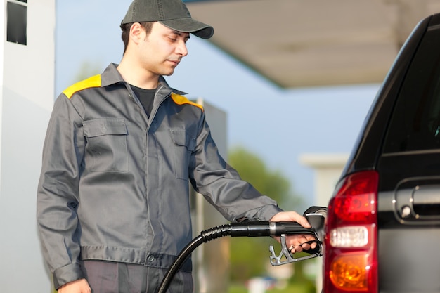 Lächelnde Arbeiter an der Tankstelle