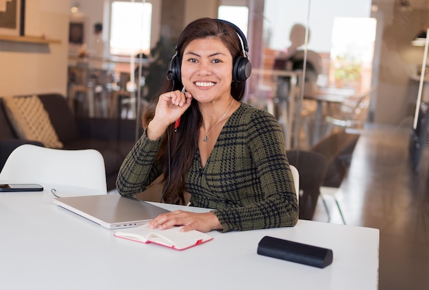 Lächelnde asiatische Frau im Headset, die als Beraterin arbeitet