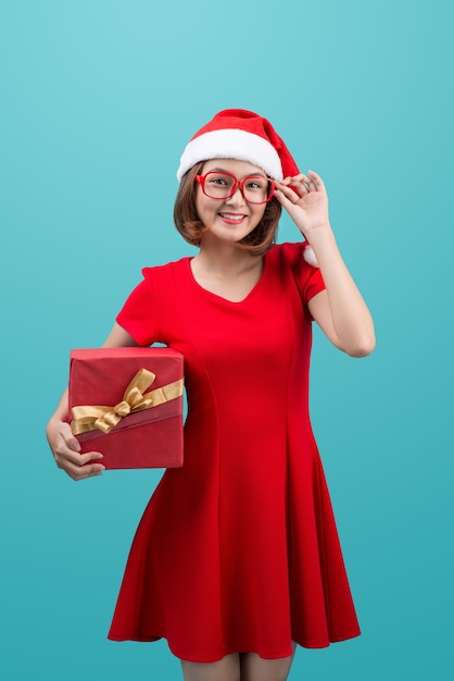Lächelnde asiatische Frau in roter Weihnachtsmütze mit Geschenkbox