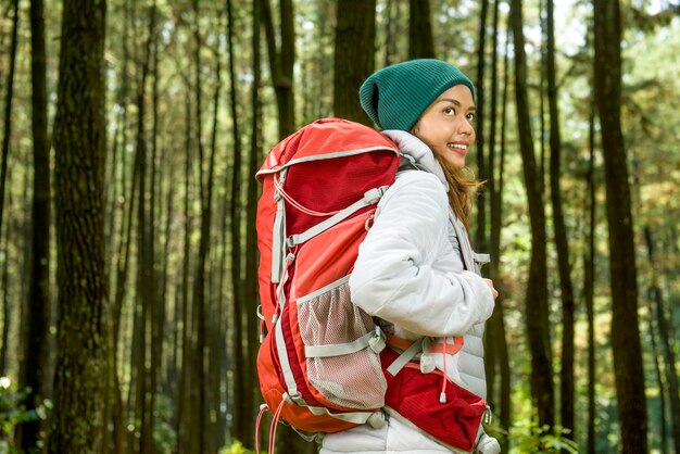 Lächelnde asiatische Reisendfrau mit Rucksack erforschen