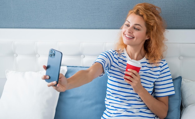 Lächelnde Bloggerin mit Kaffeezubereitung selfie am Telefon Selfie-Zeit Frau hat Videoanruf