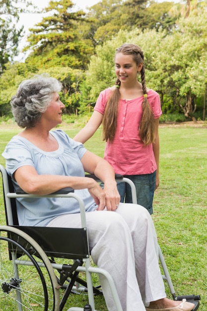 Lächelnde Enkelin mit Großmutter in ihrem Rollstuhl