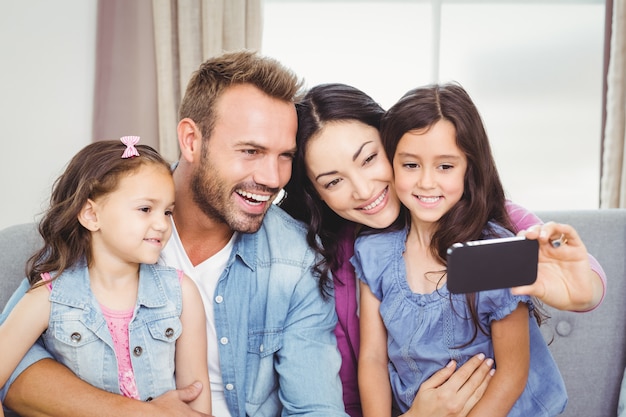 Lächelnde Familie beim Nehmen von selfie auf Mobiltelefon