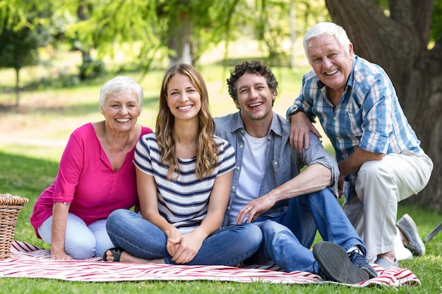 Lächelnde Familie, die auf einer Decke sitzt