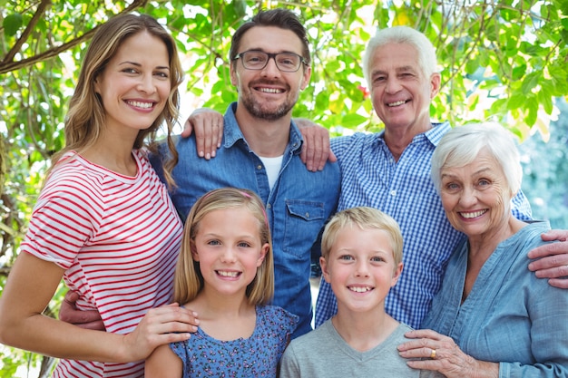 Lächelnde Familie, die gegen Baum steht