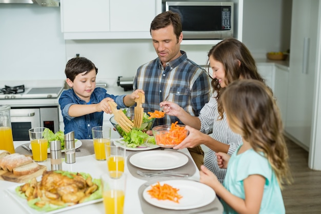 Lächelnde Familie, die zusammen auf Esstisch zu Mittag isst