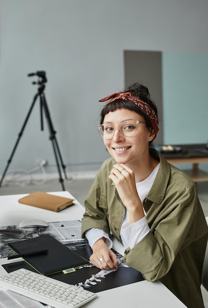 Lächelnde Fotografin am Arbeitsplatz im Studio