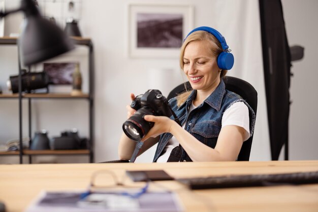 Lächelnde Fotografin in drahtlosen Kopfhörern